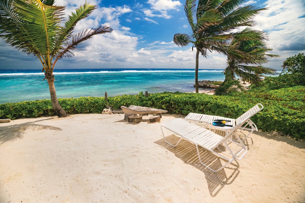 InPickleball | Grand Cayman | The Caribbean beach is just a short stroll from Villa Amoraflora, which has a pool with a pavilion over it as well as a private pickleball court